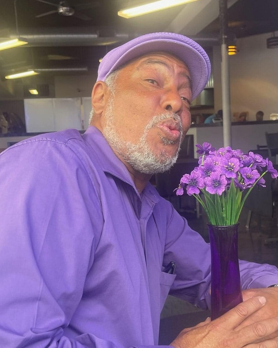 Wayne, purple cap, holding a vase of flowers
