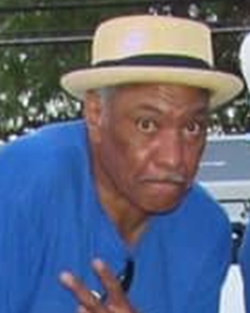 Wayne, straw hat, hand raised